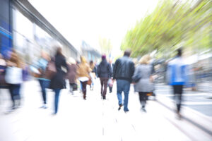 Crowd of People Walking Down Walkway Past Stores, Blurred Motion